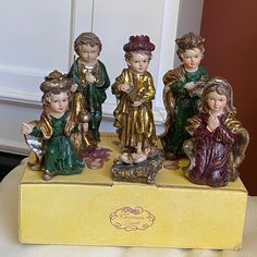 a group of figurines sitting on top of a yellow box