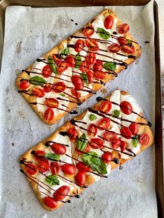 two slices of pizza with tomatoes and mozzarella drizzled on top