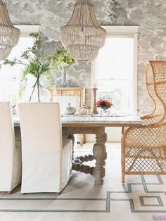 a dining room table with chairs and chandelier hanging from it's ceiling