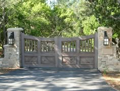 a driveway gate with two lamps on each side