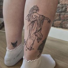 a woman's legs with tattoos on them and her leg in the shape of an angel