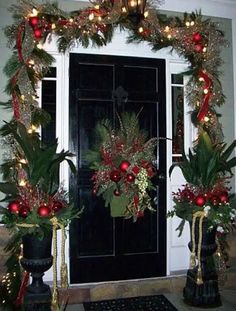 two christmas wreaths are on the front door