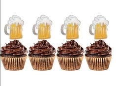 four cupcakes with frosting and beer mugs on top are lined up