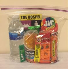 a plastic bag filled with lots of food and drink items next to a water bottle