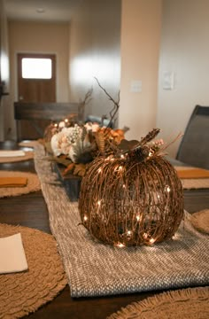 the table is set with pumpkins and flowers