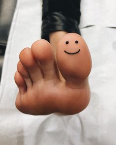 a person's foot with a smiley face painted on it