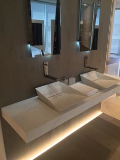 a bathroom with three sinks and mirrors on the wall