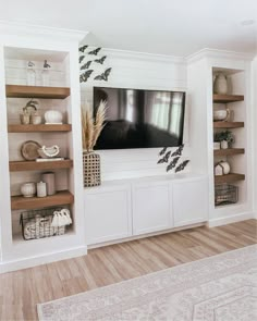 a living room with shelves and a flat screen tv mounted to the side of it