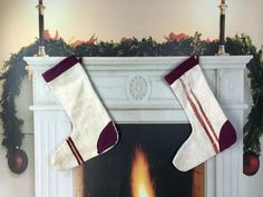 two stockings hanging over a fireplace with christmas decorations