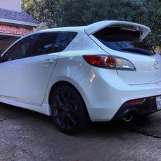 a white car parked in front of a house