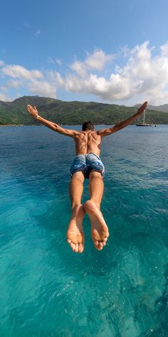 a man jumping into the water from a boat