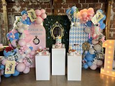 balloons and decorations are on display in front of a brick wall at a birthday party