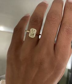 a woman's hand with a yellow diamond ring on her left and right hand