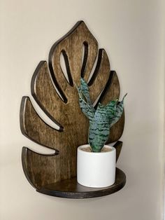 a potted plant sitting on top of a wooden shelf