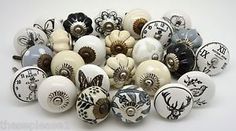 an assortment of ceramic knobs with different designs on them, all in black and white