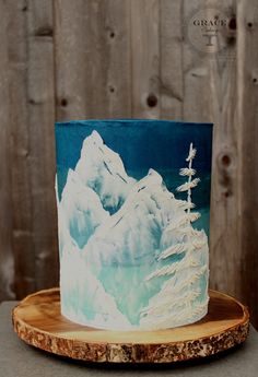 a blue and white cake sitting on top of a wooden plate