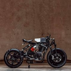 a black and white motorcycle parked in front of a wall