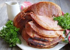 ham on a plate with parsley next to a cup of coffee and napkins