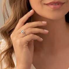 a woman wearing a ring with a diamond on it