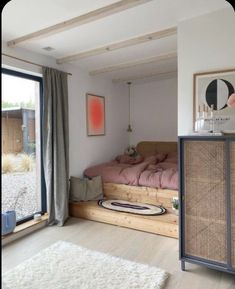 a bedroom with a bed, dresser and window in the corner that looks out onto the yard