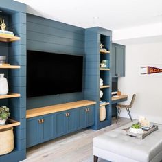 a living room filled with furniture and a flat screen tv mounted on a wall next to a window