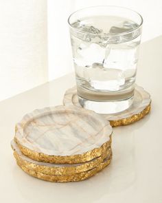 marble coasters with gold leaf accents and a glass of water