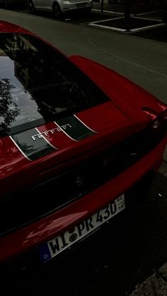 a red sports car is parked on the street