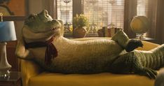 a stuffed alligator laying on top of a yellow chair