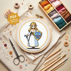 an embroidery kit with scissors, thread and needle markers on the table next to it