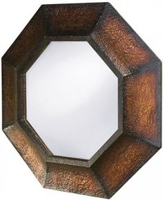 a mirror that is sitting on top of a wall with a brown frame and metal decoration