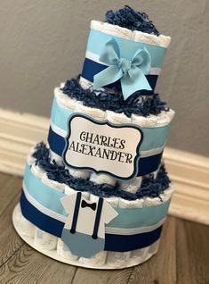 a three tiered blue and white diaper cake with name on it's side