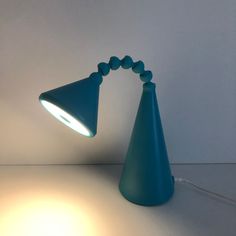 a blue lamp sitting on top of a table next to a white wall and floor