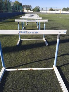 several white benches sitting on top of a soccer field