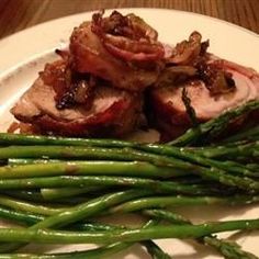 some meat and asparagus on a white plate