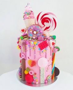 a pink cake with candy, candies and lollipops