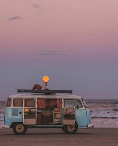 an old vw bus parked on the beach at dusk