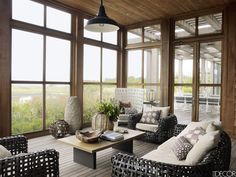 a living room filled with lots of furniture and large windowed windows next to each other