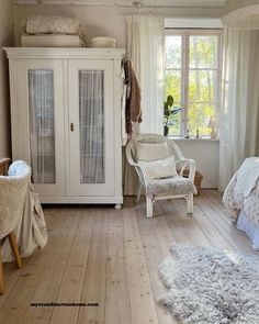 a bedroom with white furniture and wooden floors