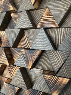 some wood pieces are stacked together on top of each other in the shape of triangles