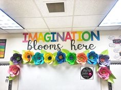 an office decorated with colorful paper flowers and congratulations blooms here written on the front wall