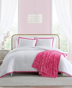 a pink and white bed in a bedroom