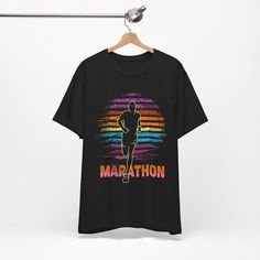 Introducing the Marathon T-Shirt, a perfect blend of comfort, style, and motivation for all the dedicated runners who conquer the roads. Available with express delivery in navy, black and dark grey heather, this runner t-shirt features a bold and inspiring design, a silhouetted runner against a striped colored sunset background with a shirt that proudly displays "Marathon", a graphic that symbolizes the relentless spirit of marathon runners. The vibrant colors and sharp details of the print make Sporty Cotton T-shirt For Running, Graphic Print Short Sleeve Activewear For Running, Printed Graphic Tee Activewear With Crew Neck, Crew Neck T-shirt For Running, Sports Season Running T-shirt With Short Sleeves, Sporty Running T-shirt With Logo Print, Athleisure Crew Neck T-shirt With Sublimation Print, Letter Print T-shirt For Running, Sporty Running T-shirt With Letter Print