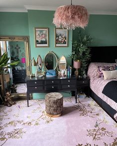 a bedroom with a bed, dresser and mirror on the wall next to a pink rug