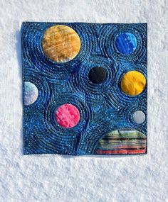 a piece of art that is made out of paper and fabric with different planets on it