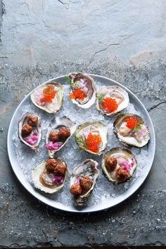 several oysters on an ice tray with red cavia