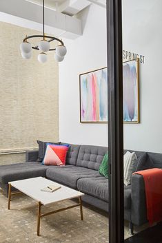 a living room with couches, tables and paintings hanging on the wall above them