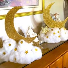 there are clouds and stars on top of the moon in front of an angel figurine