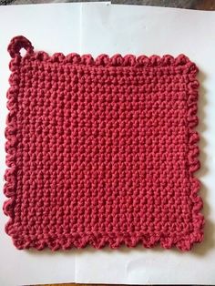 a piece of crocheted cloth sitting on top of a white sheet of paper