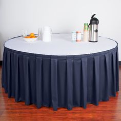 a round table with a green cloth on it and two coffee mugs next to it