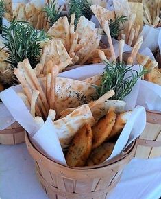 baskets filled with different types of food on top of a table next to white plates